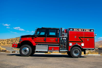 Wildland fire apparatus driving in the mountains on a sunny day