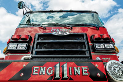 A close up view of a red fire truck red bumper that reads ‘Engine 11’.