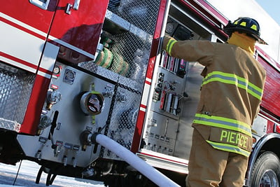 Fire fighter standing next to a PUC Pump Panel