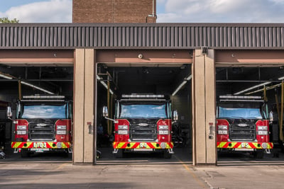 A fire department has five of seven bay doors open showing parked fire apparatus inside.