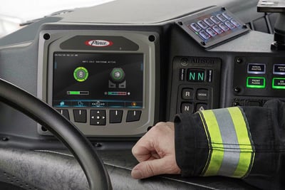 Idle reduction technology is shown on a screen in a fire truck as a firefighter looks on.