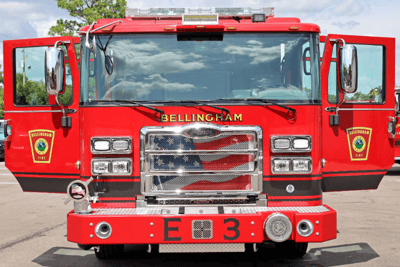 A straight-on front shot of the red Bellingham fire truck with an American flag on the grill.