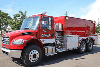 A red Pierce fire tanker truck with water pump controls and side compartments.