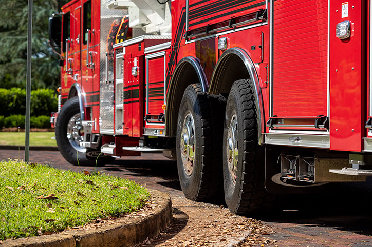 An aerial fire truck driving around a corner on the road with TAK-4 rear steer.