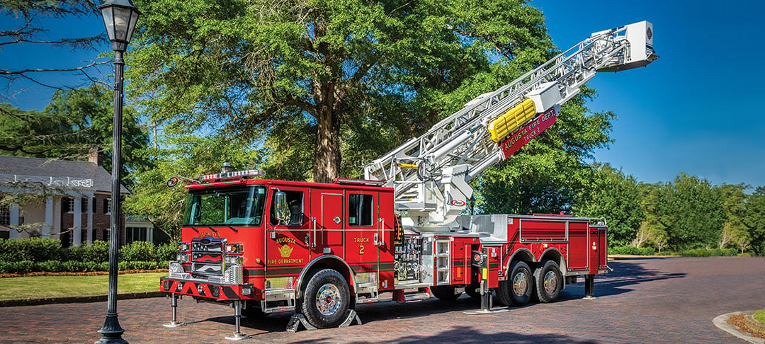 Enforcer 100 Heavy Duty Aerial MidMount Tower parked on a road with the ladder extended and stabilizers down.