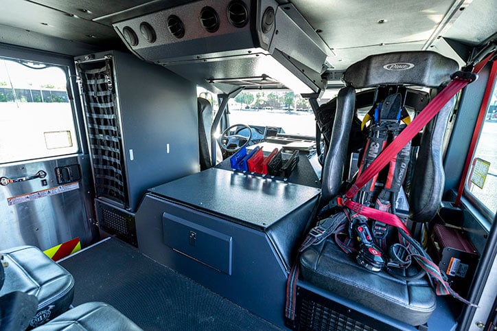 The crew cab interior of a fire truck showing seats and compartments.