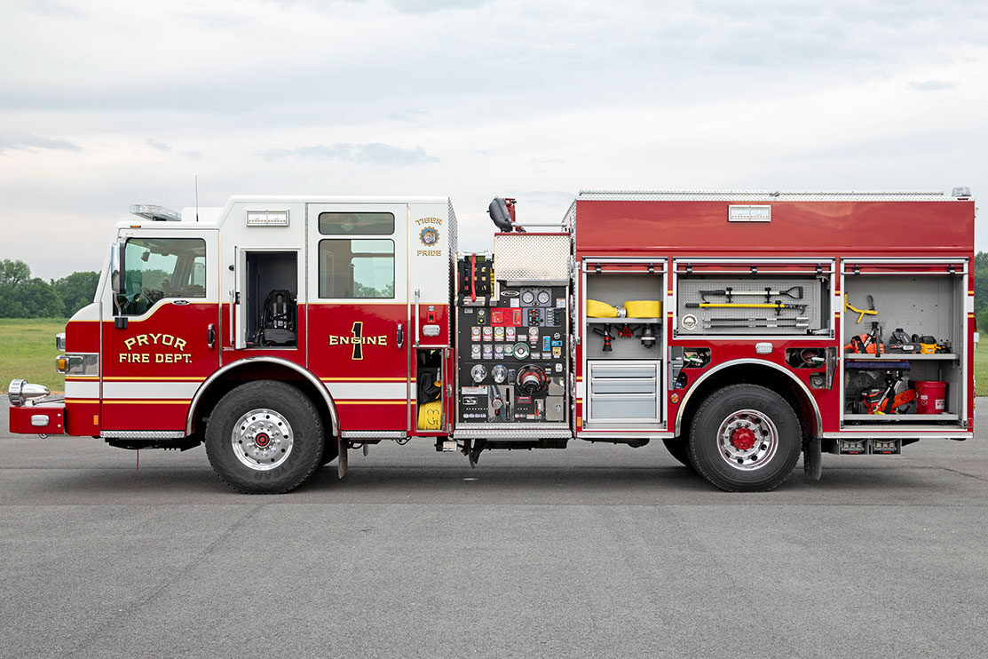 The drivers side of a Velocity Pumper with the compartments open showing tools, equipment and hose inside.