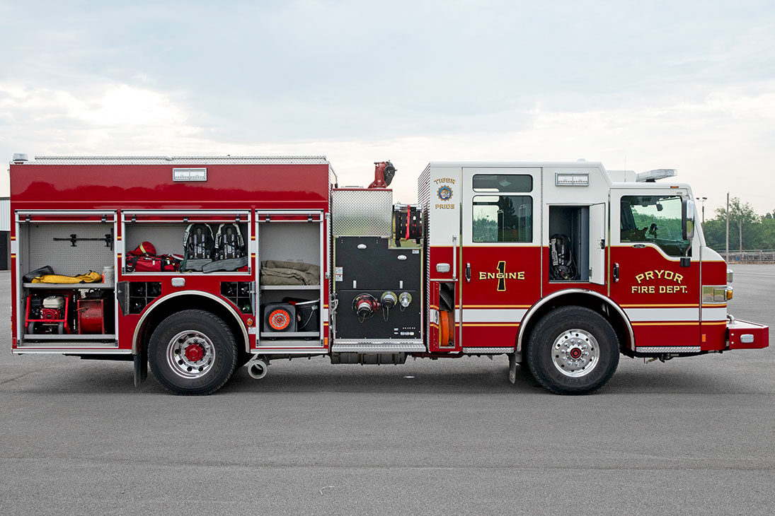 The officers side of a Velocity Pumper with the compartments open showing tools and equipment inside.