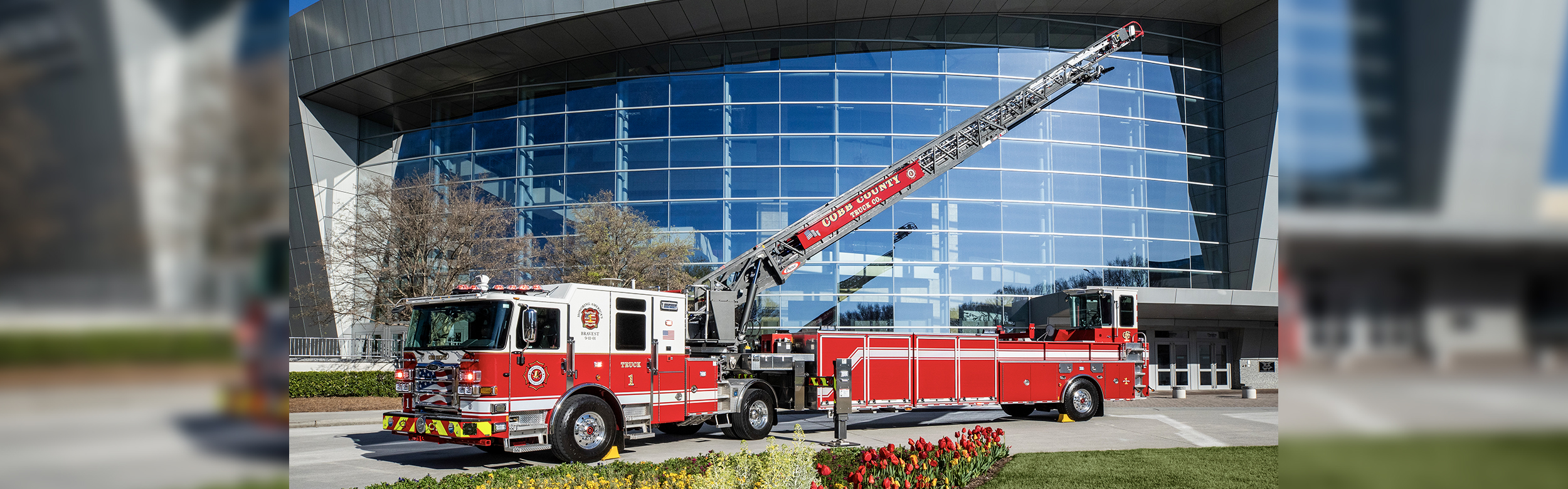 An Enforcer 107' Ascendant Tractor Drawn Aerial with the ladder extended in front of a large building.