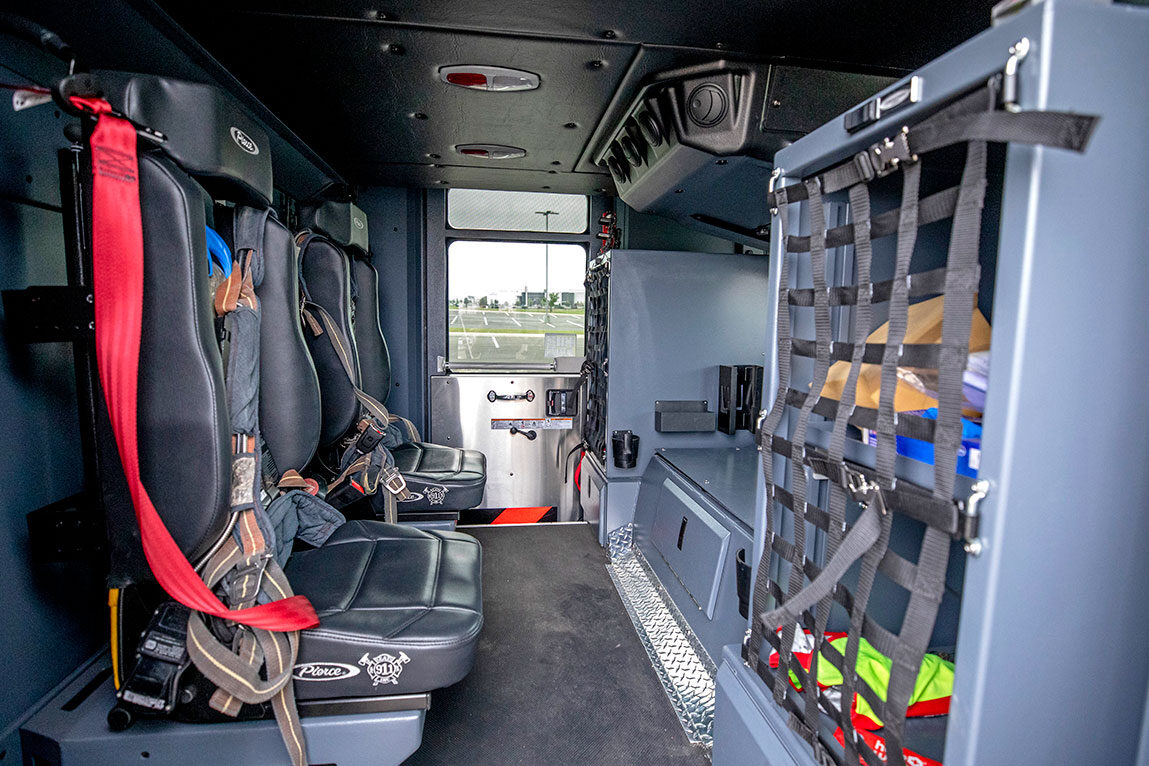 The crew cab of a fire truck with two forward facing seats.