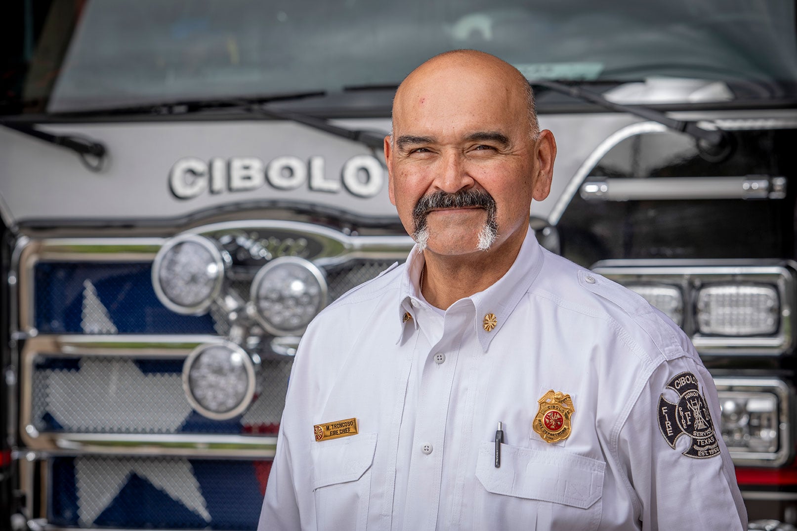The fire chief for Cibolo Fire Department posed in front of a fire truck.