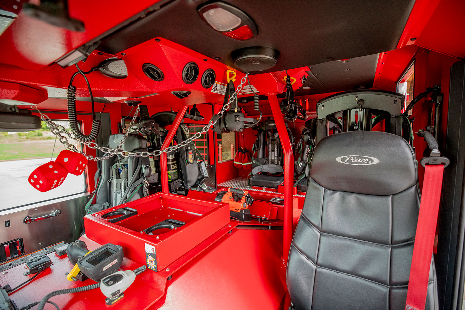 The inside of a fire truck crew cab with red interior.