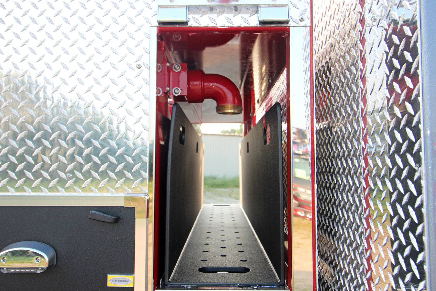 An empty speedlay tray of a fire truck behind the cab.