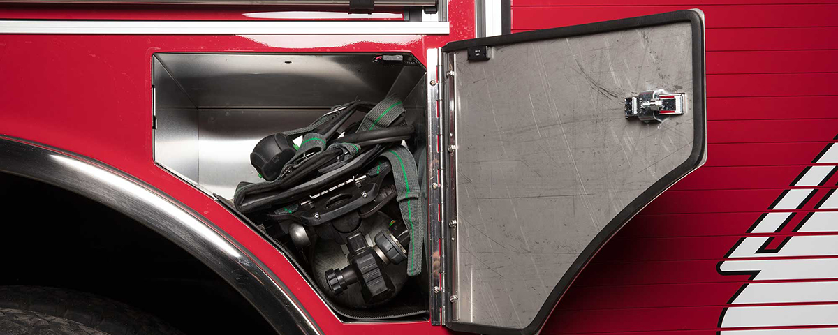 Fender panel compartment with a clean cab concept on the side of a Pierce fire truck storing SCBA gear. 