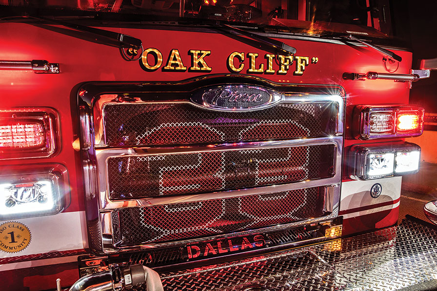 Custom fire truck grill on pumper fire truck with emergency lights flashing