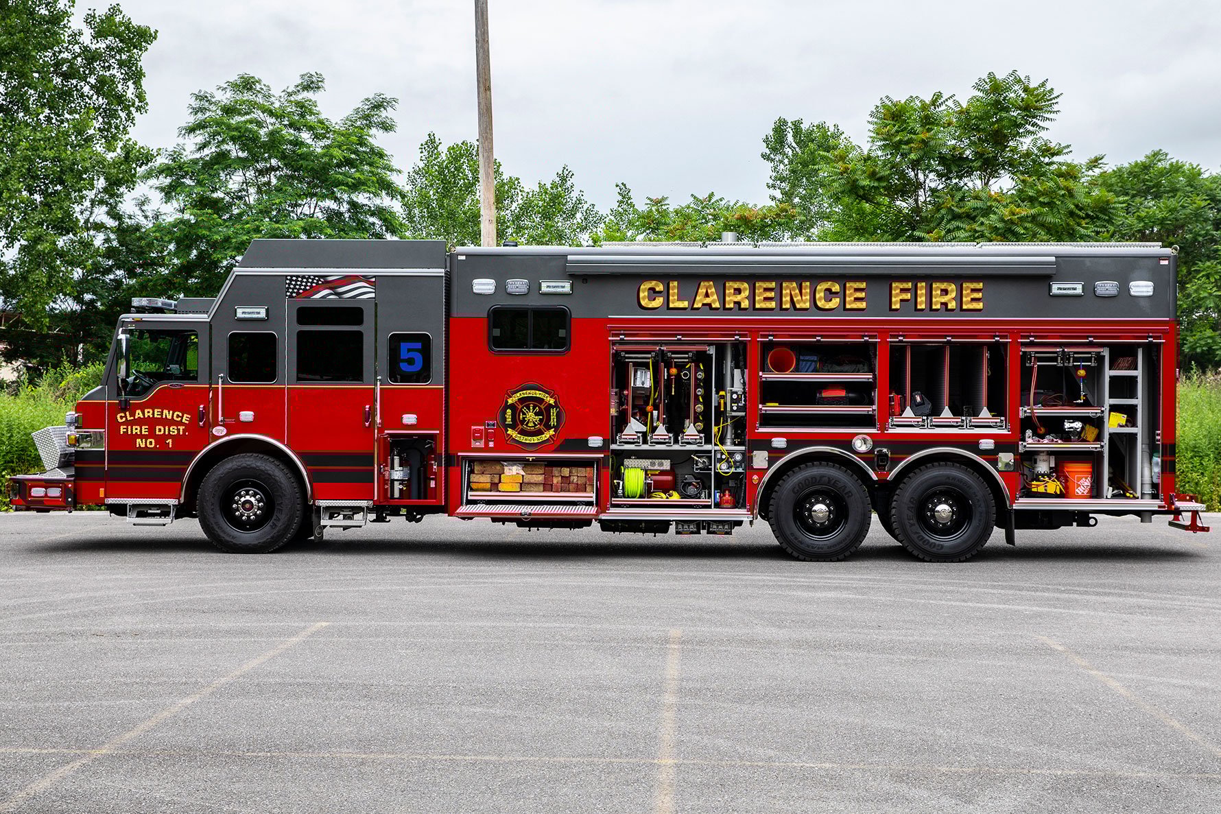The driver's side of a Velocity Combination Heavy-Duty Rescue with the compartments open showing equipment and tools inside.