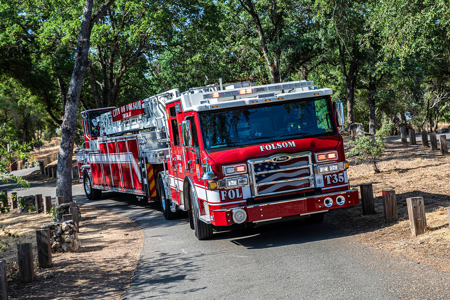 The front officer's side of a Velocity Ascendant 107 Heavy-Duty Tractor Drawn Aerial driving up a steep narrow rural road.
