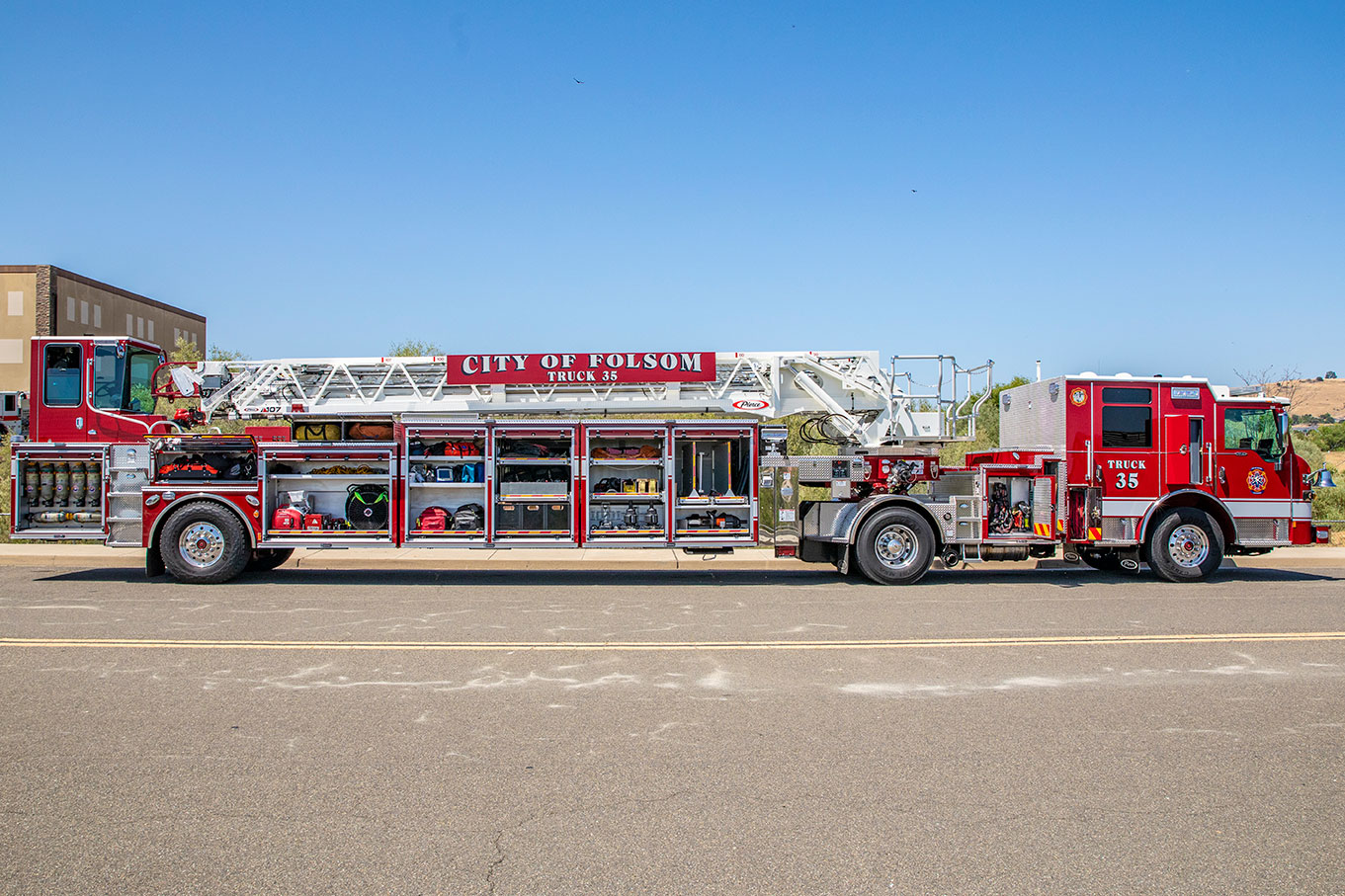 The officer's side of a Velocity Ascendant 107 Heavy-Duty Tractor Drawn Aerial with the compartments open showing equipment.