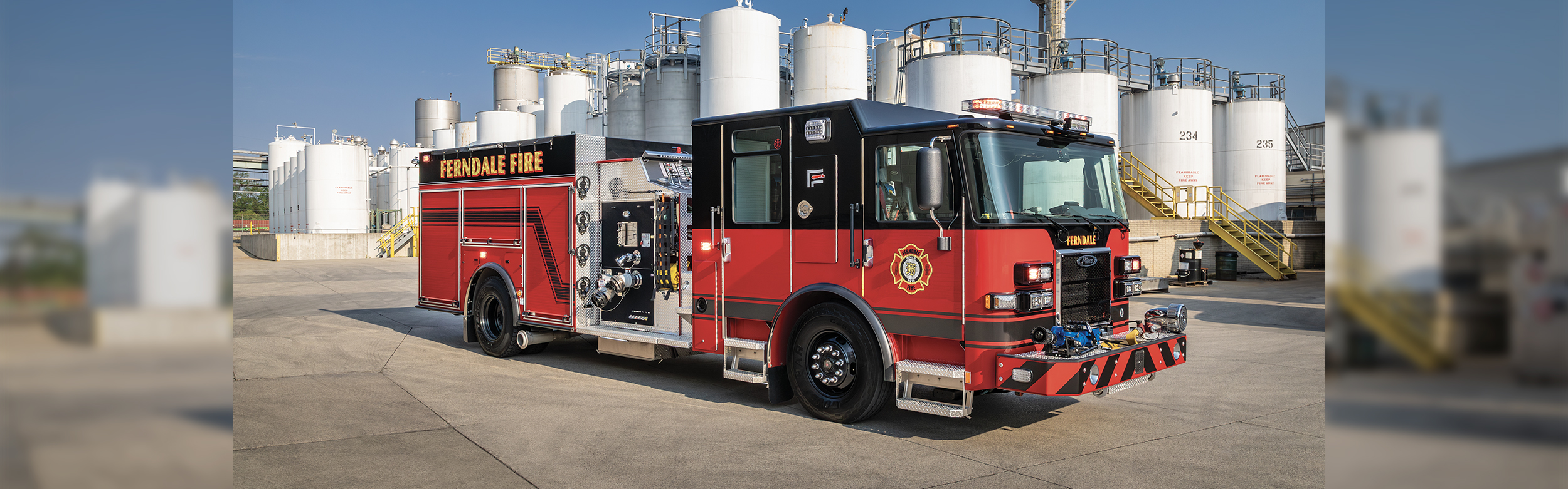The front officer's side of a Saber Pumper fire truck parked in front of a chemical plant on a sunny day. (2)