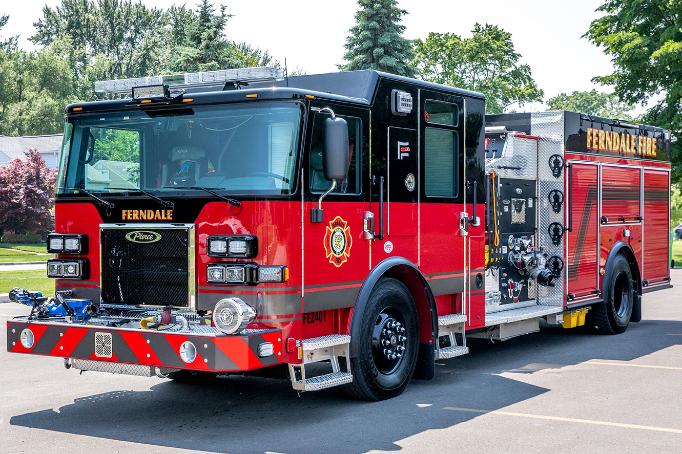 The front drivers side of a Saber Pumper fire truck parked in a parking lot on a sunny day.