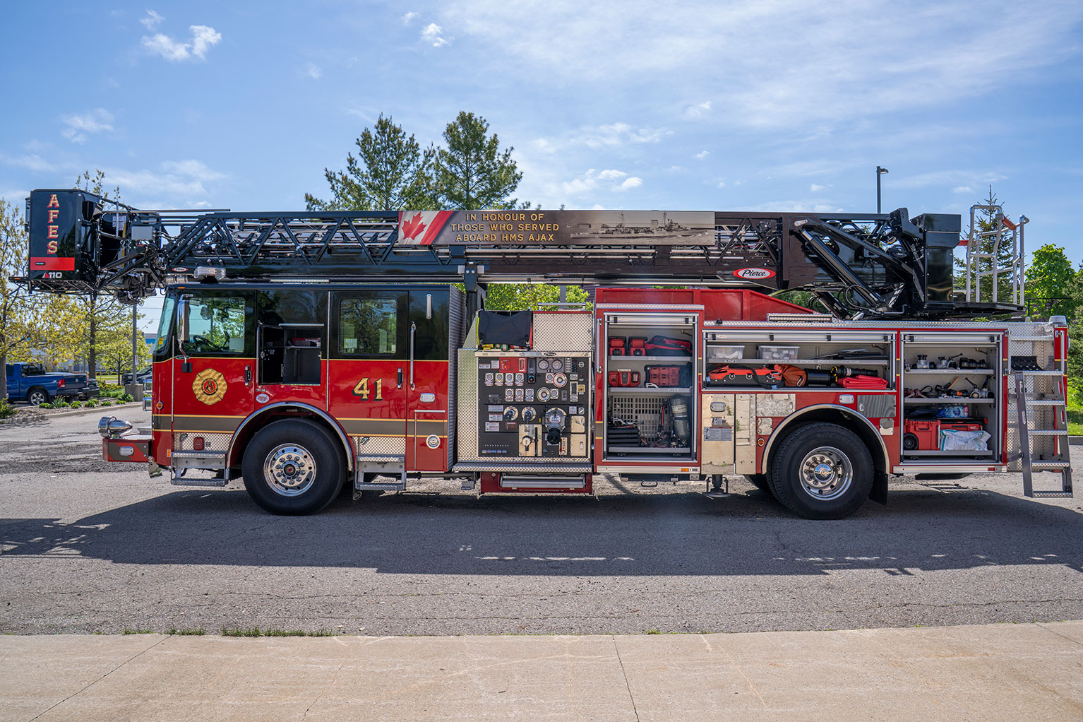 The drivers side of an Enforcer 110 Ascendant Aerial Platform with the compartments open showing equipment and tools inside.