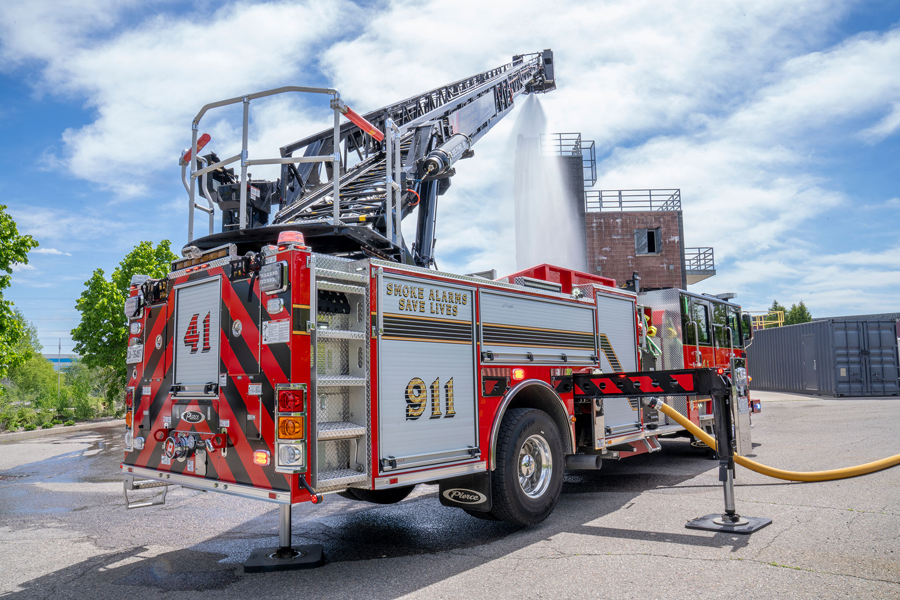 The rear drivers side of an Enforcer 110 Ascendant Aerial Platform with the aerial extended flowing water.