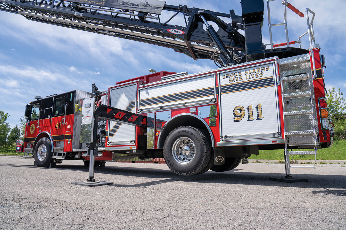 The rear drivers side of an Enforcer 110 Ascendant Aerial with the stabilizers deployed and aerial extended.