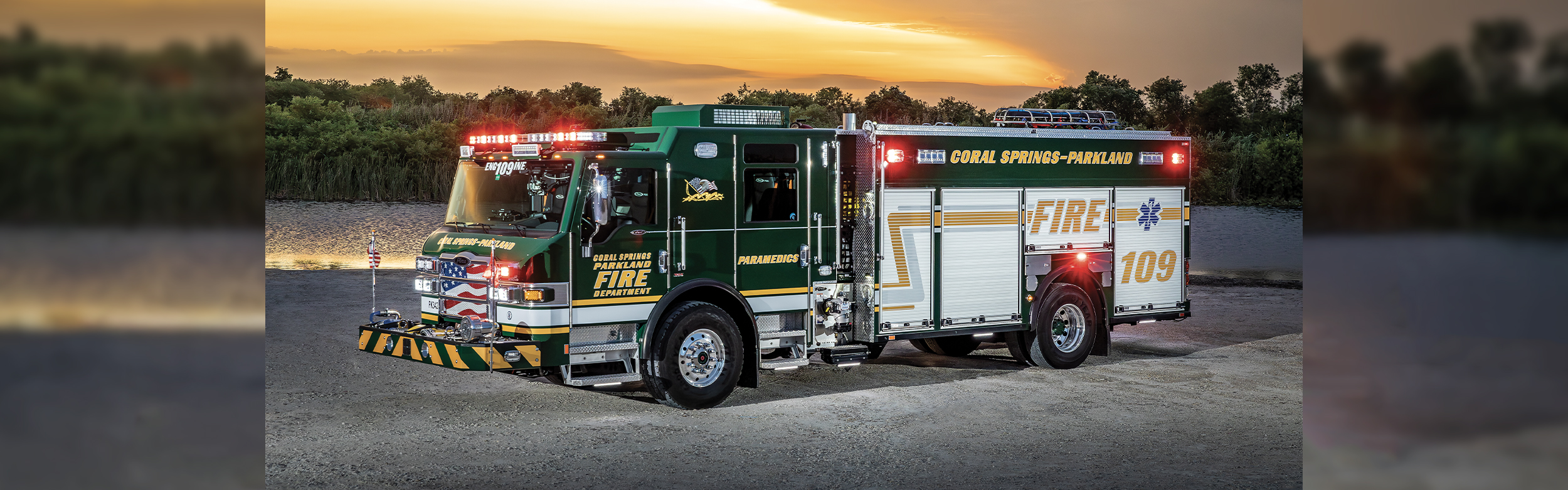 Cover The front drivers side of an Impel PUC Pumper parked on gravey by water and a marsh area with a sunset behind.