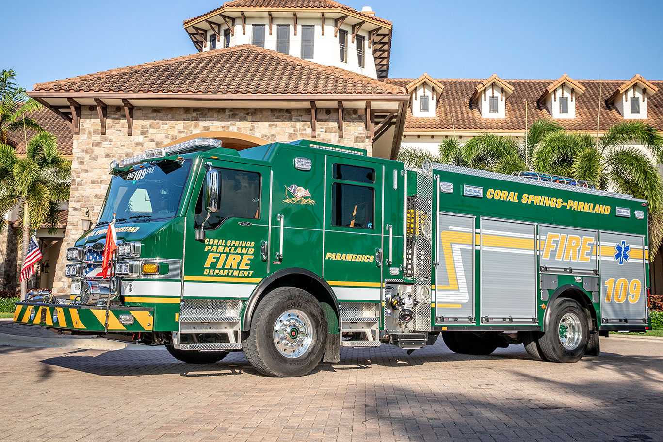The front drivers side of an Impel PUC Pumper parked on cobblestone in front of a large brick building.