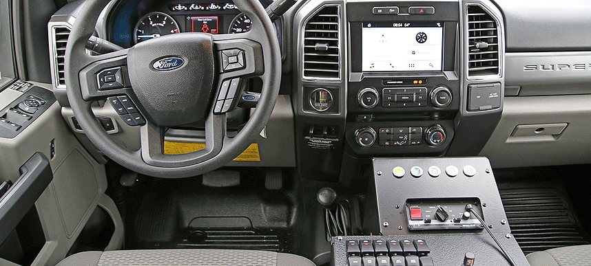 Black leather interior steering wheel, radio and drivers side seat configuration of a Pierce Ford commercial chassis. 