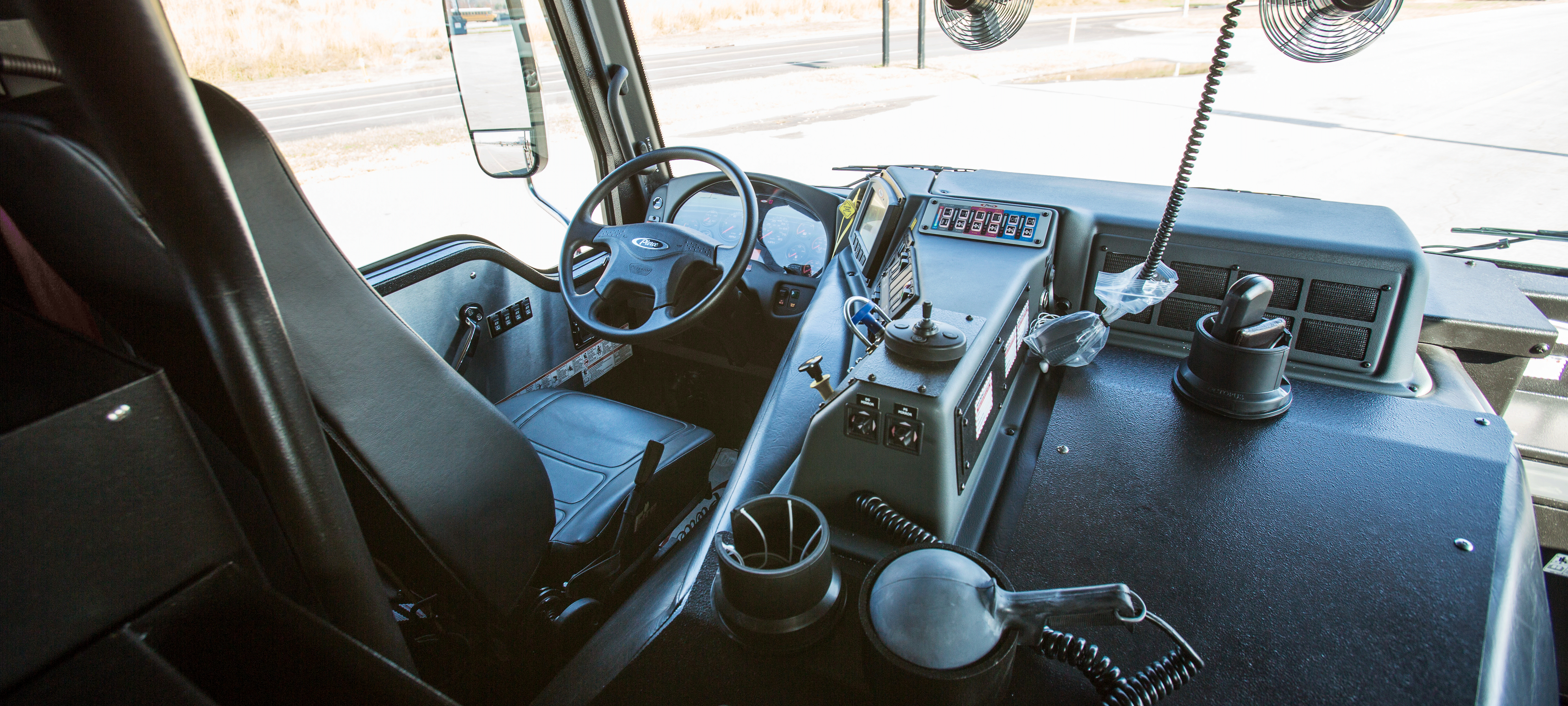 Driver's side of a Pierce Impel custom fire truck with black seating and black interior. 