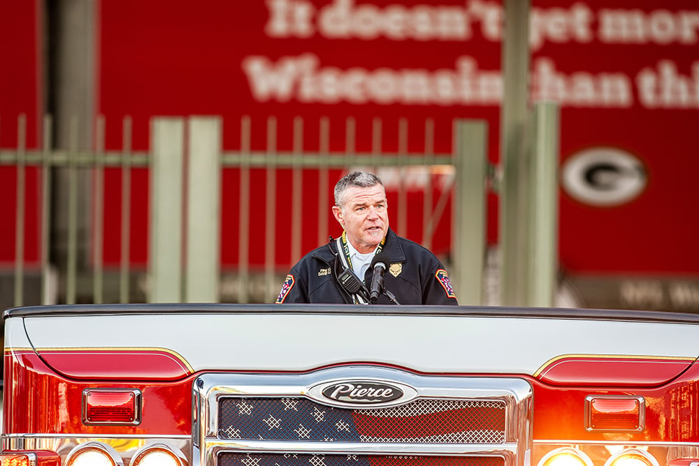 A Fire Chief giving a speech at Lambeau Field at the Pierce Manufacturing 9/11 Memorial Stair Climb Event.