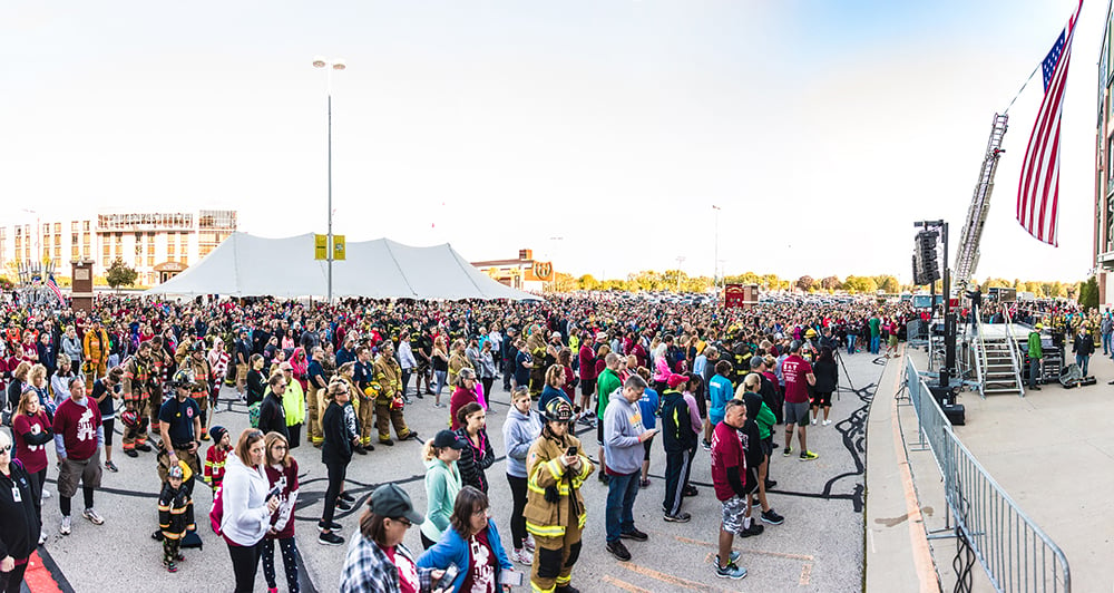 People gathering outside of Lambeau Field on a sunny day at the Pierce Manufacturing 9/11 Memorial Stair Climb opening ceremony.