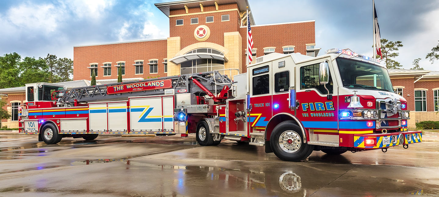 Pierce Ascendant 107' Heavy-Duty Tiller Aerial Ladder Fire Truck parked outside in front of a fire station. 