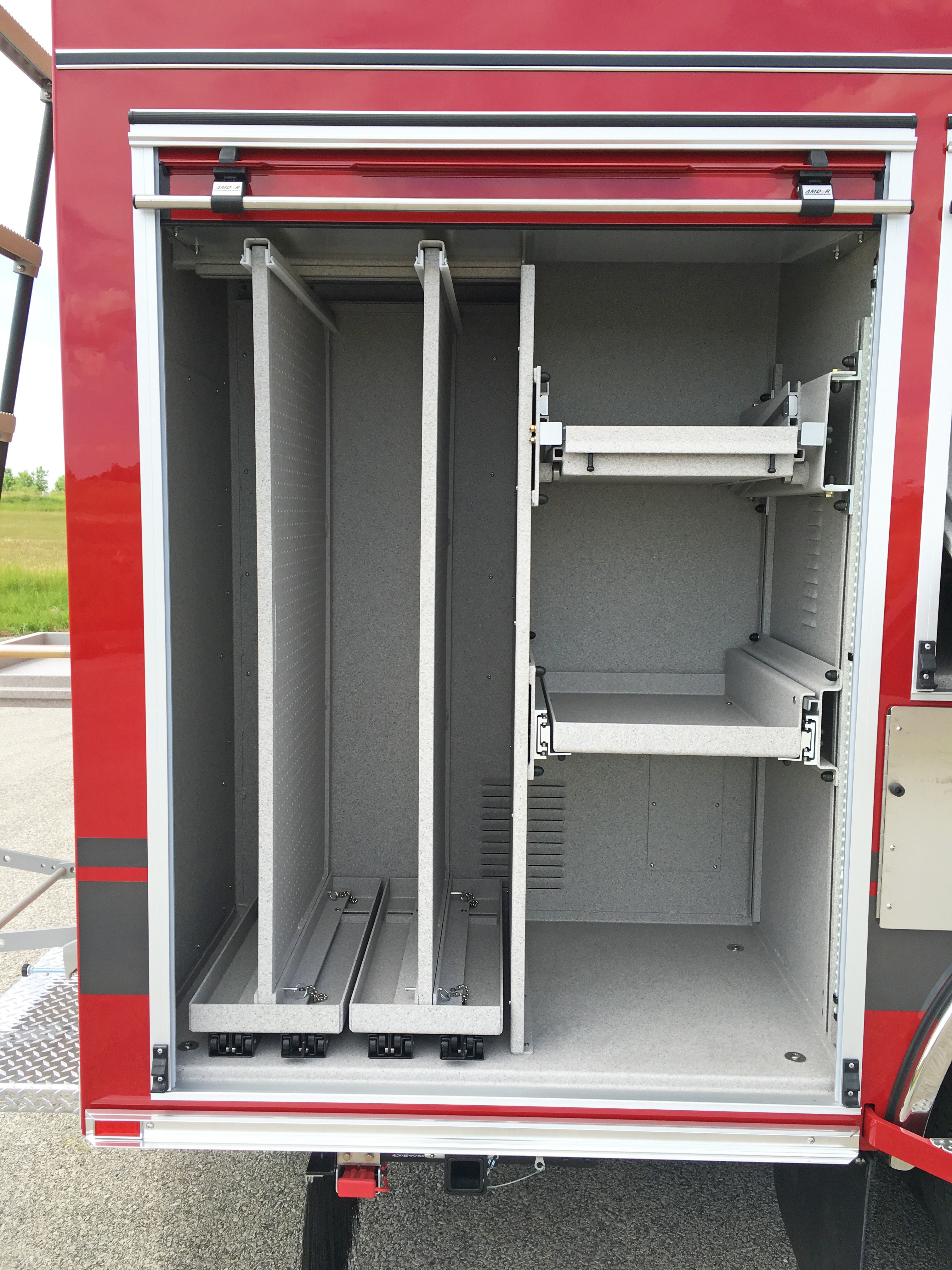 Pierce Combination Rescue Fire Truck parked outside in a parking lot with Passenger’s side roll up door open showing storage space.  