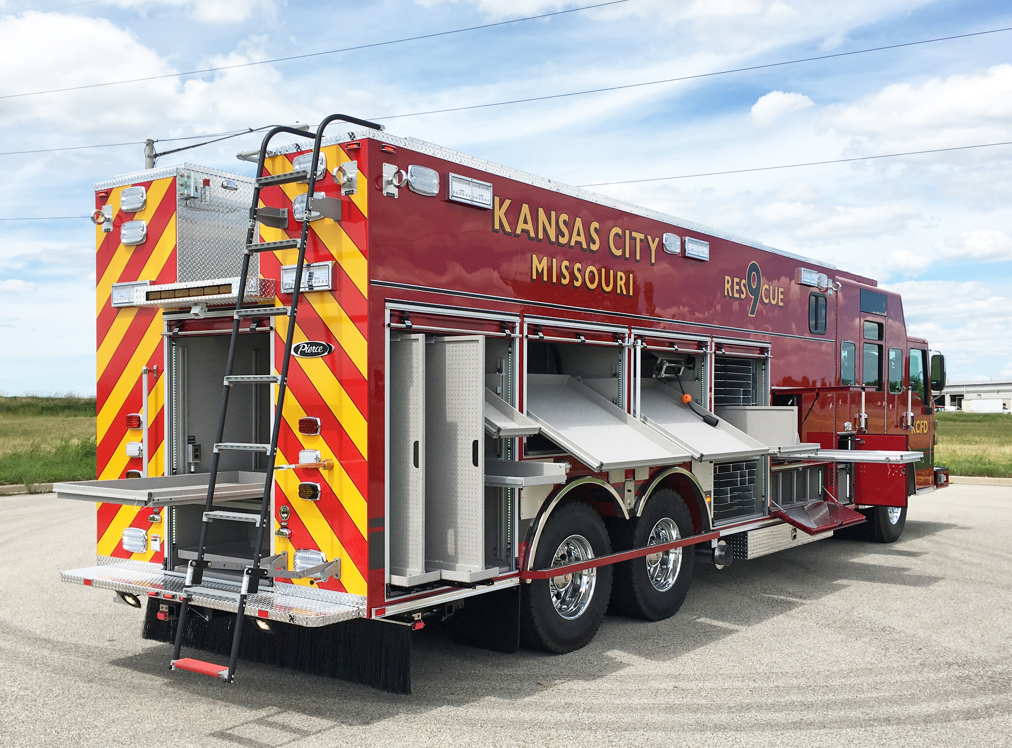 Pierce Combination Rescue Fire Truck parked outside in a parking lot with Passenger’s side and rear compartments open showing storage space. 