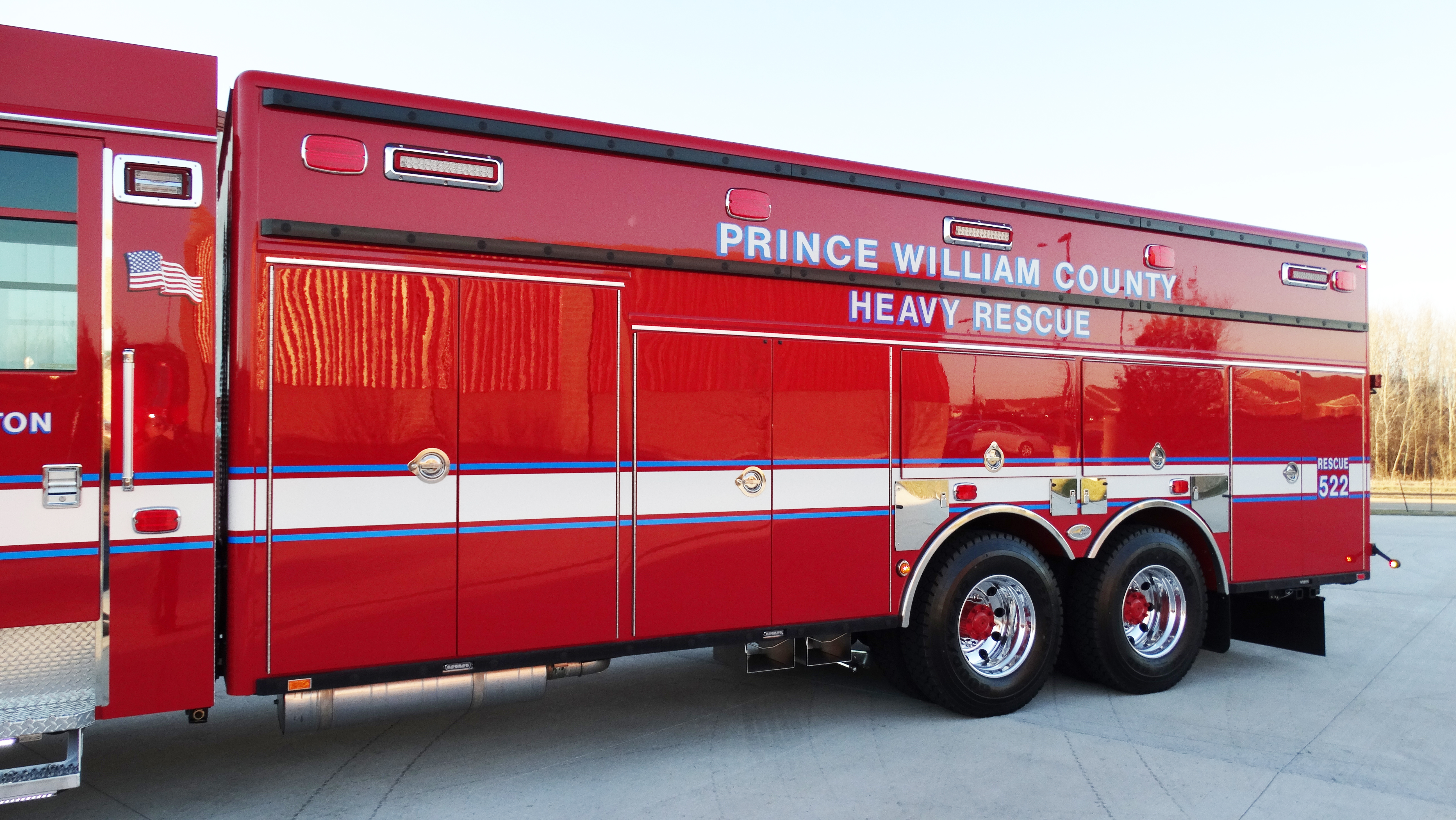 Officer’s side of a Pierce Combination Rescue Fire Truck for Prince William County parked outside in a parking lot. 