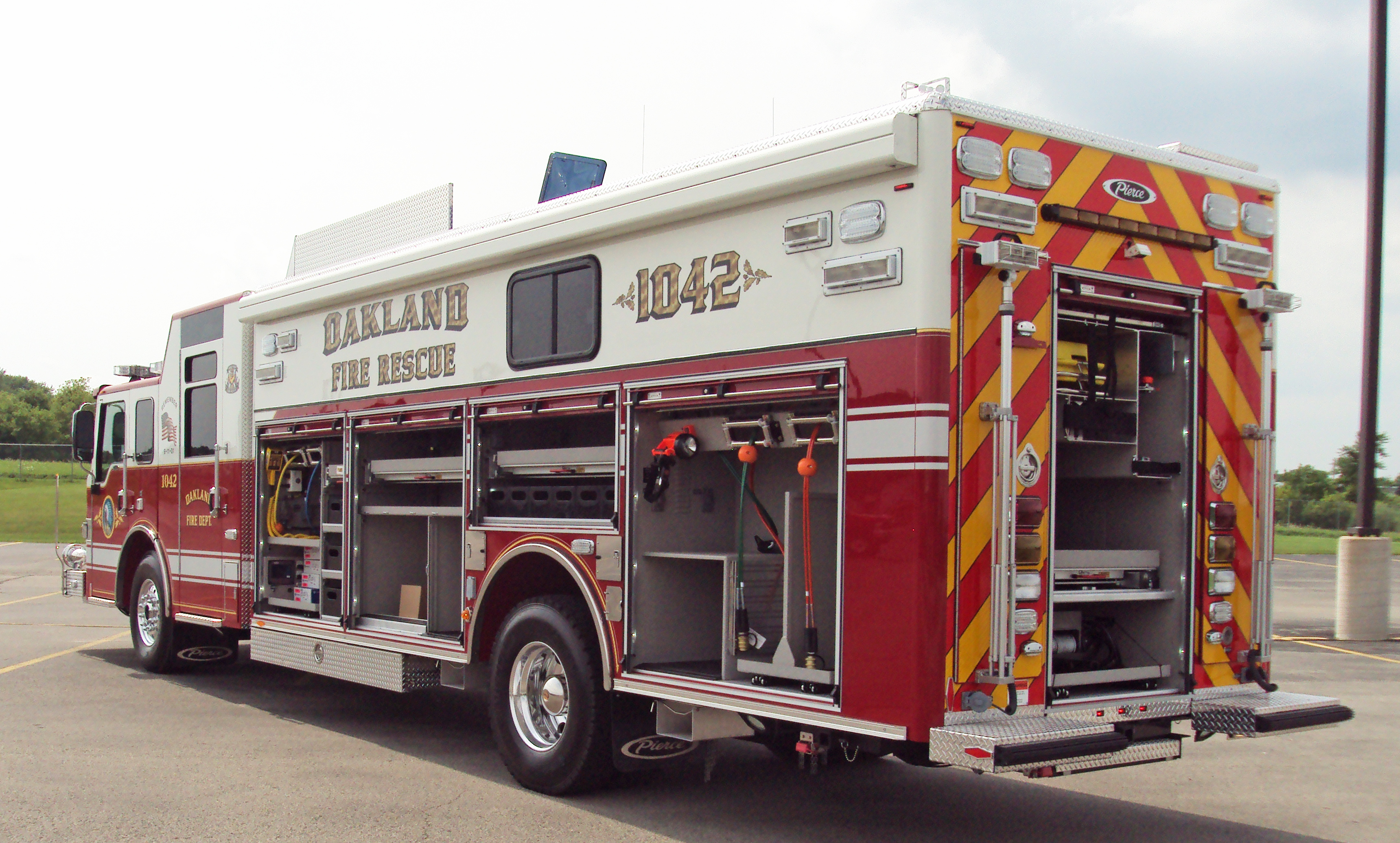 Pierce Combination Rescue Fire Truck parked outside with officer’s side and rear compartments open showing storage space. 