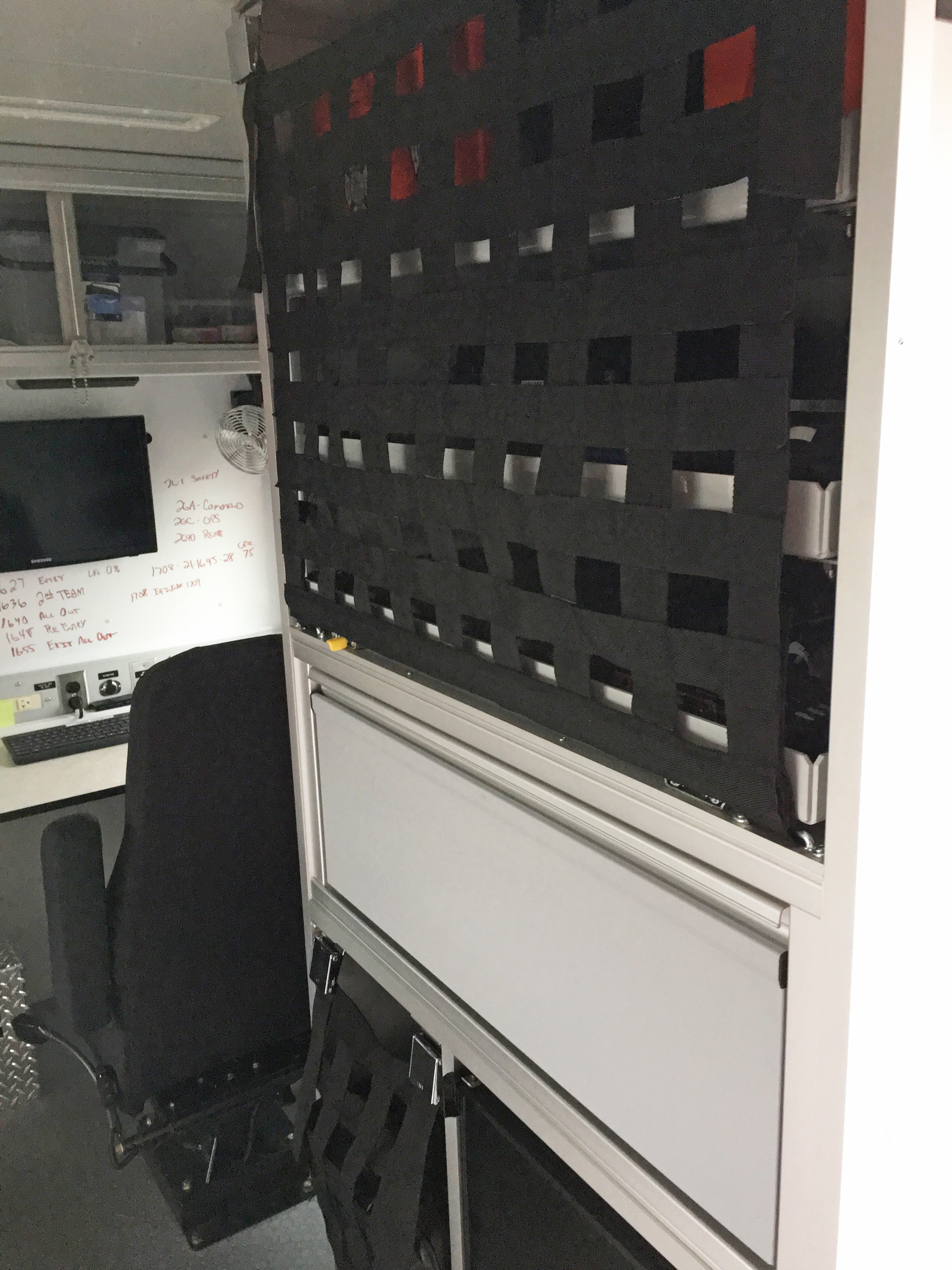 Interior shelving on a Pierce Combination Rescue Fire Truck with black safety netting. 