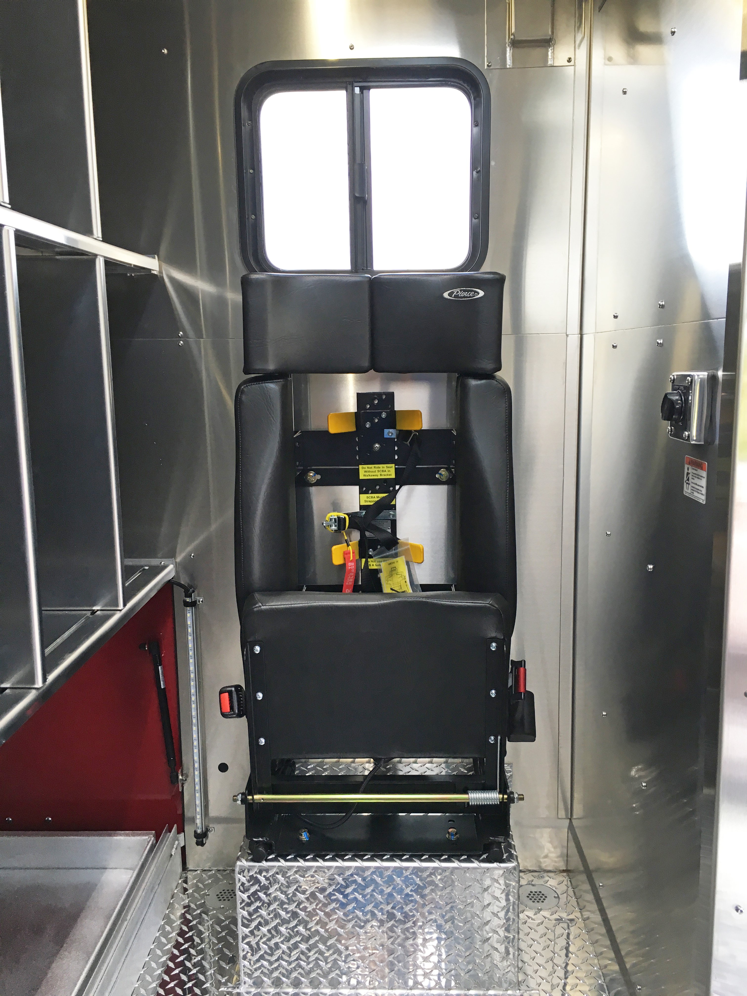 Black vinyl seat in the rear of a Pierce Combination Rescue Fire Truck. 