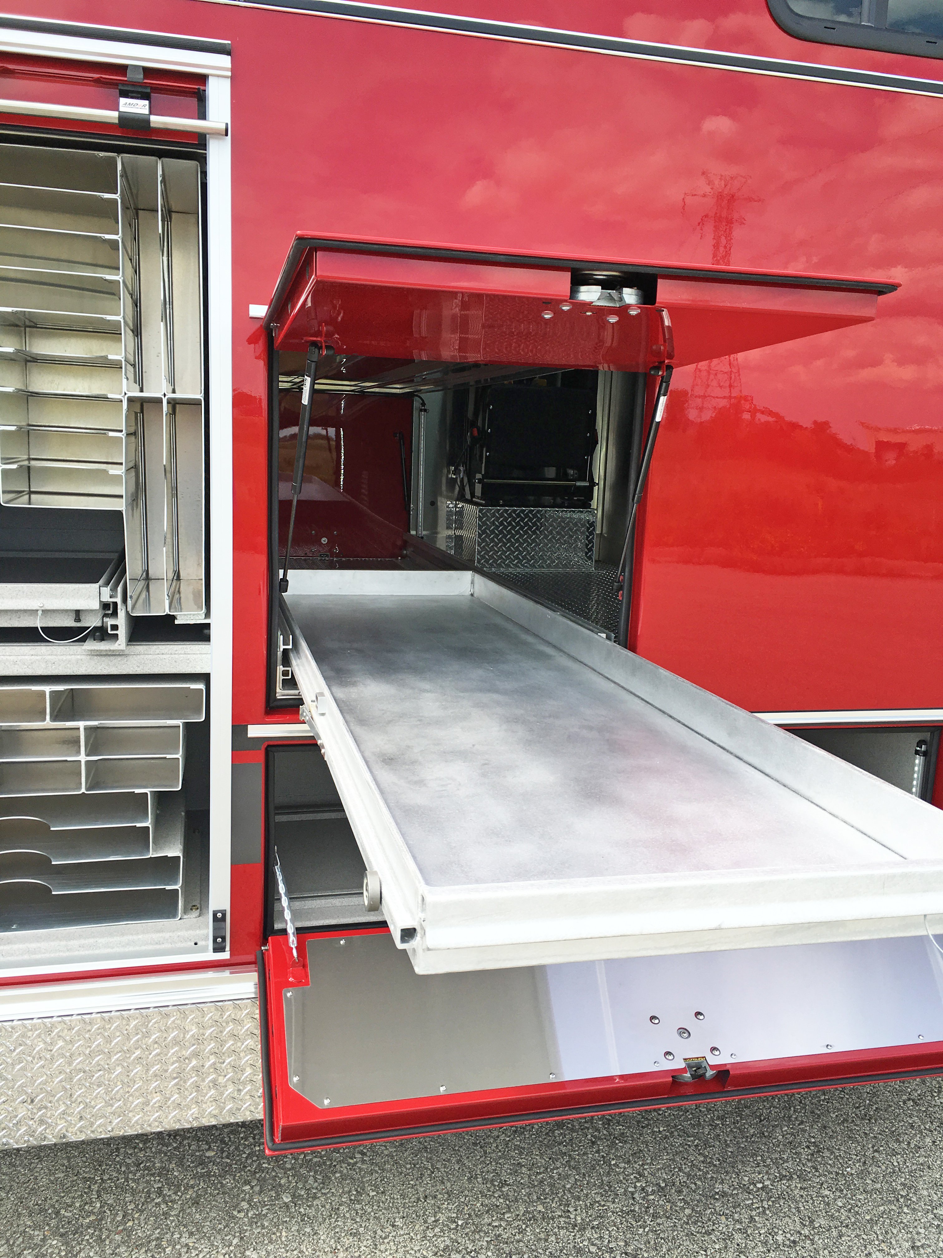 Side compartment of a Pierce Combination Rescue Fire Truck with the drawer slid out showing length and storage space. 