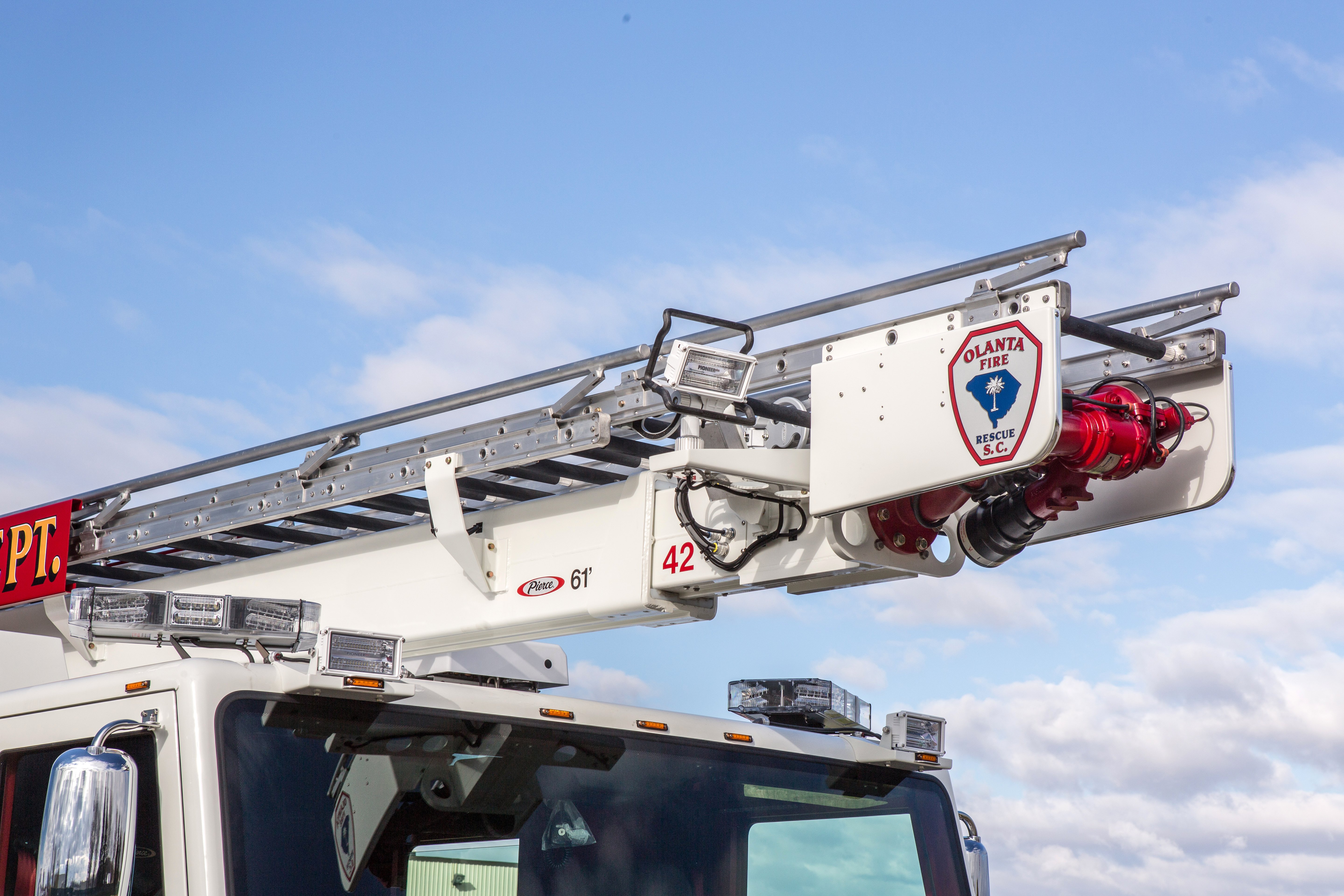 Water Tower on top of a Pierce Heavy-Duty Sky-Boom Aerial fire truck parked outside. 