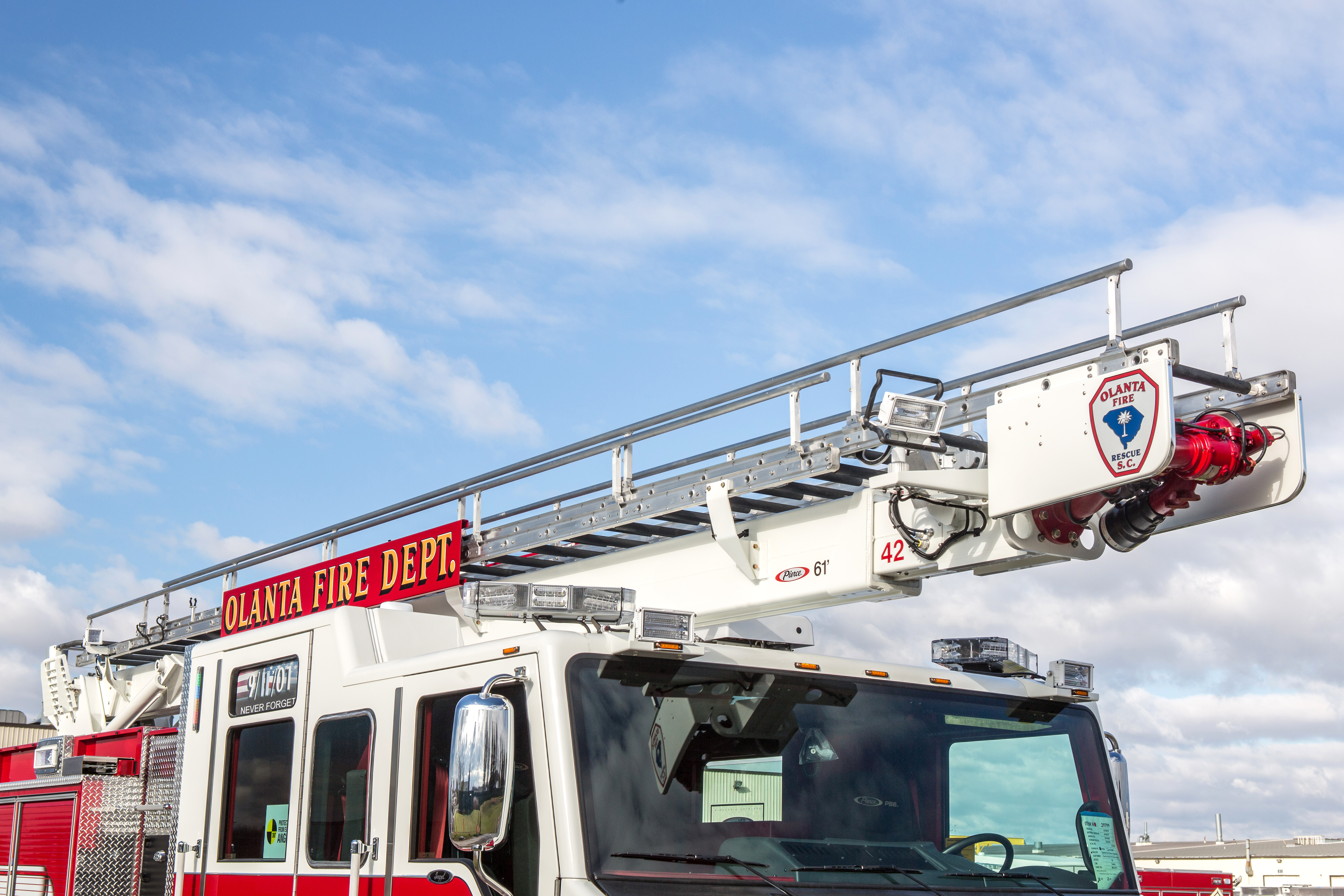 Water Tower on top of a Pierce Heavy-Duty Sky-Boom Aerial fire truck parked outside. 