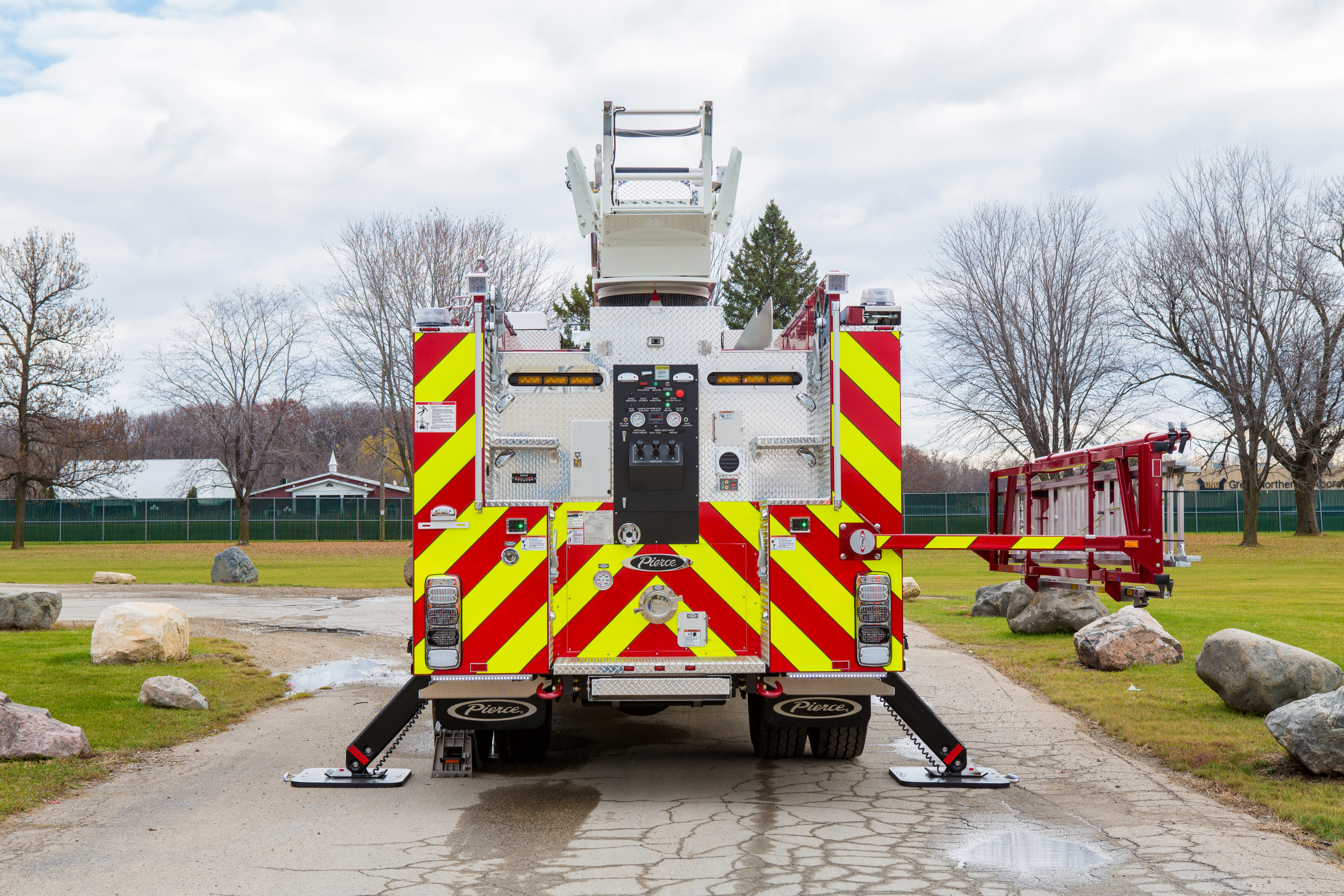 Pierce Heavy-Duty Sky-Boom Aerial Water Tower parked outside with stabilizers on each side and the ladder rack extended on the right side. 