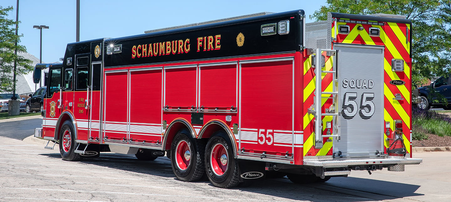 Pierce Non-Walk-In Heavy-Duty Rescue Fire Truck parked outside in a parking lot on a sunny day near trees. 