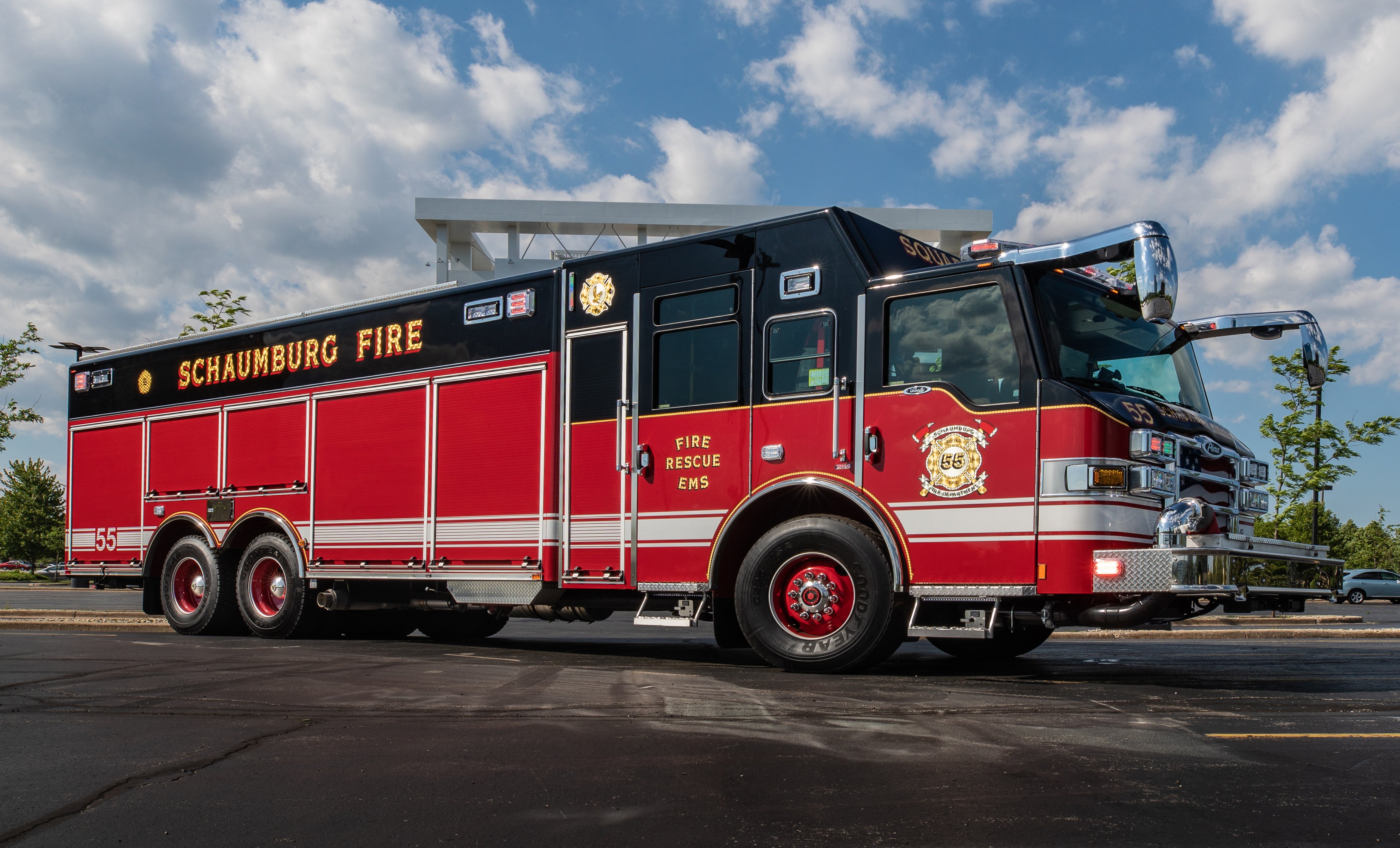 Passenger’s side of a Pierce Non-Walk-In Rescue Fire Truck parked outside in a parking lot on a sunny day. 