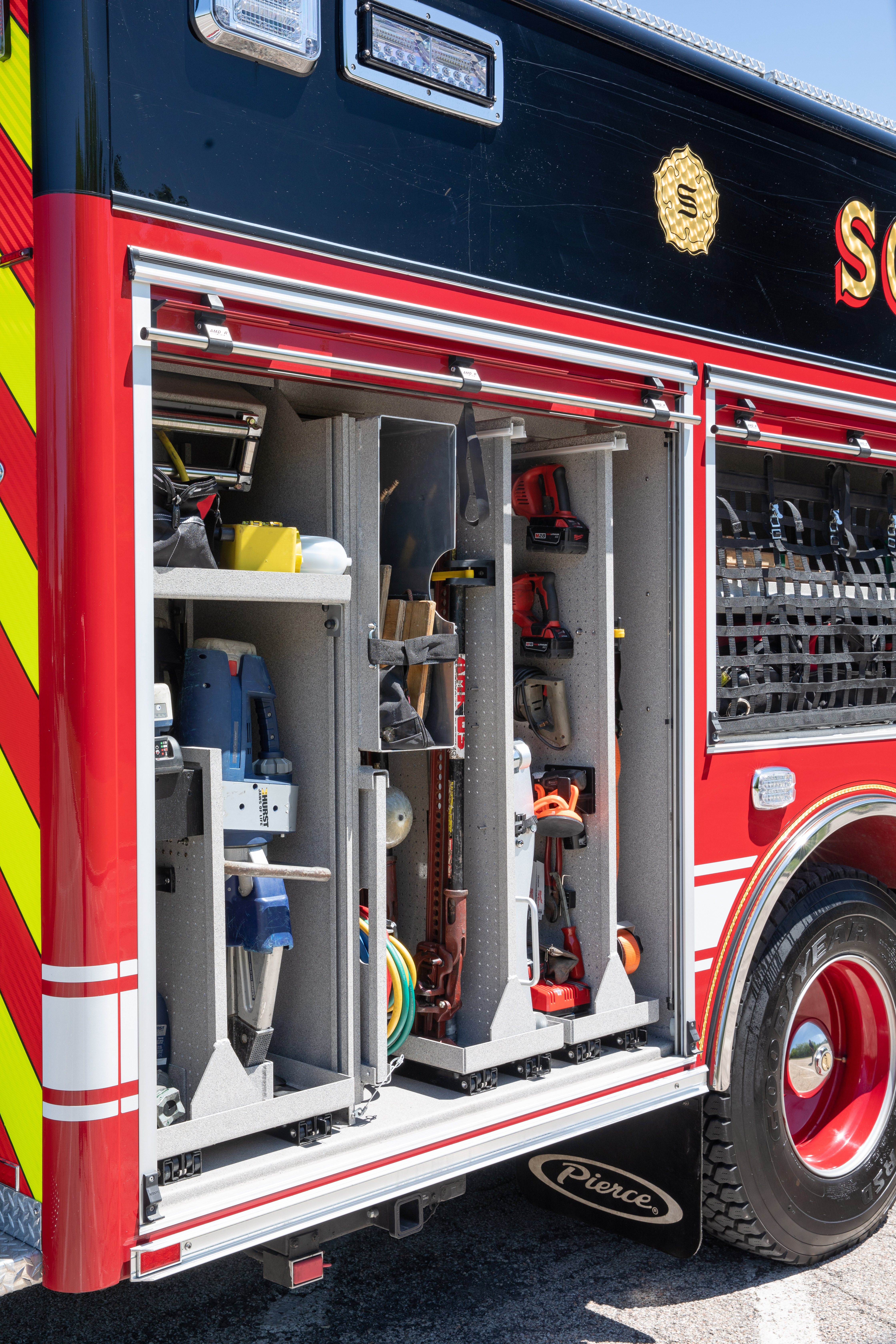 Pierce Non-Walk-In Rescue Fire Truck parked in a parking lot with compartments open showing rear shelving and storage space. 