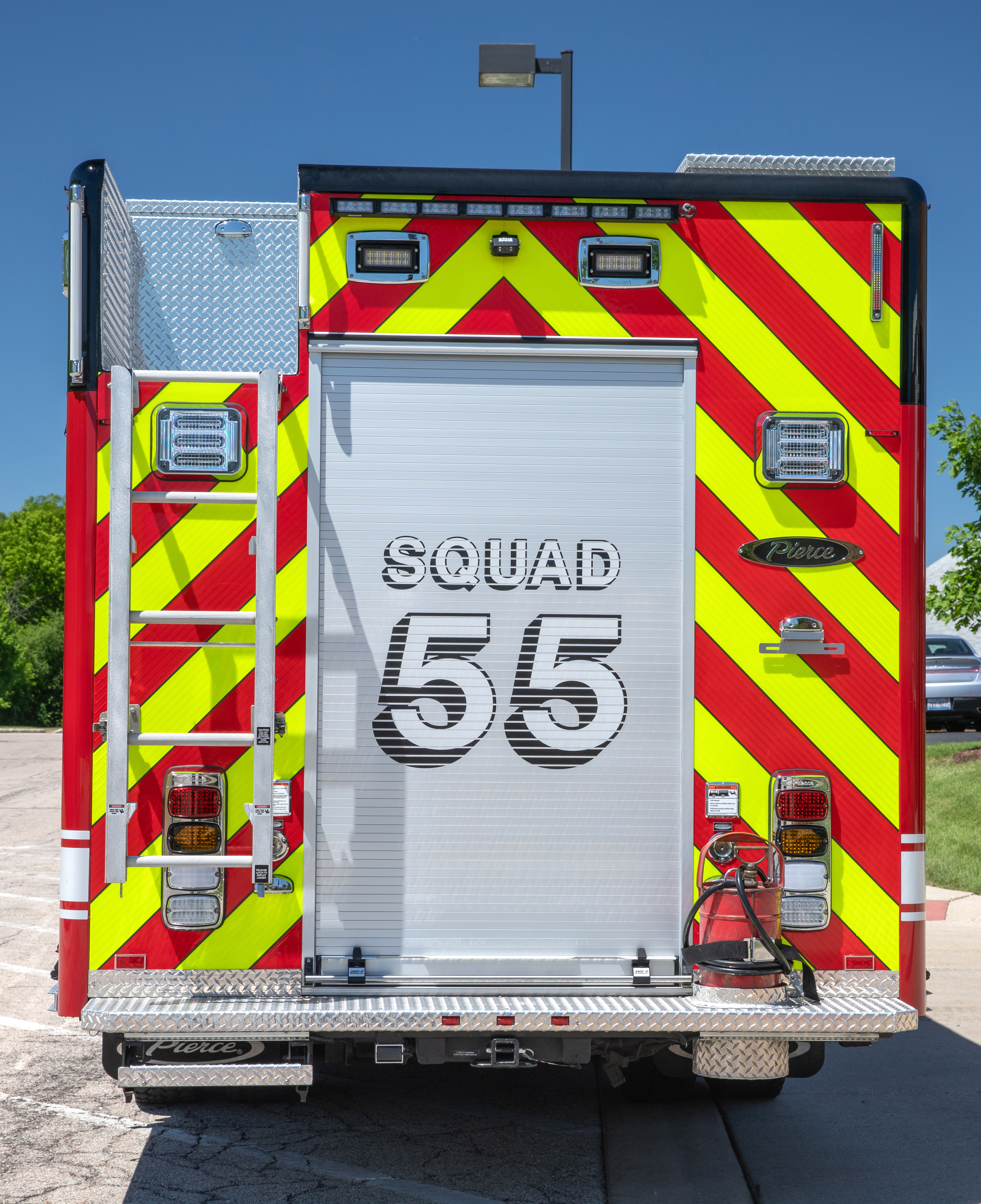 Rear of a Pierce Non-Walk-In Rescue Fire Truck parked outside in a parking lot on a sunny day. 