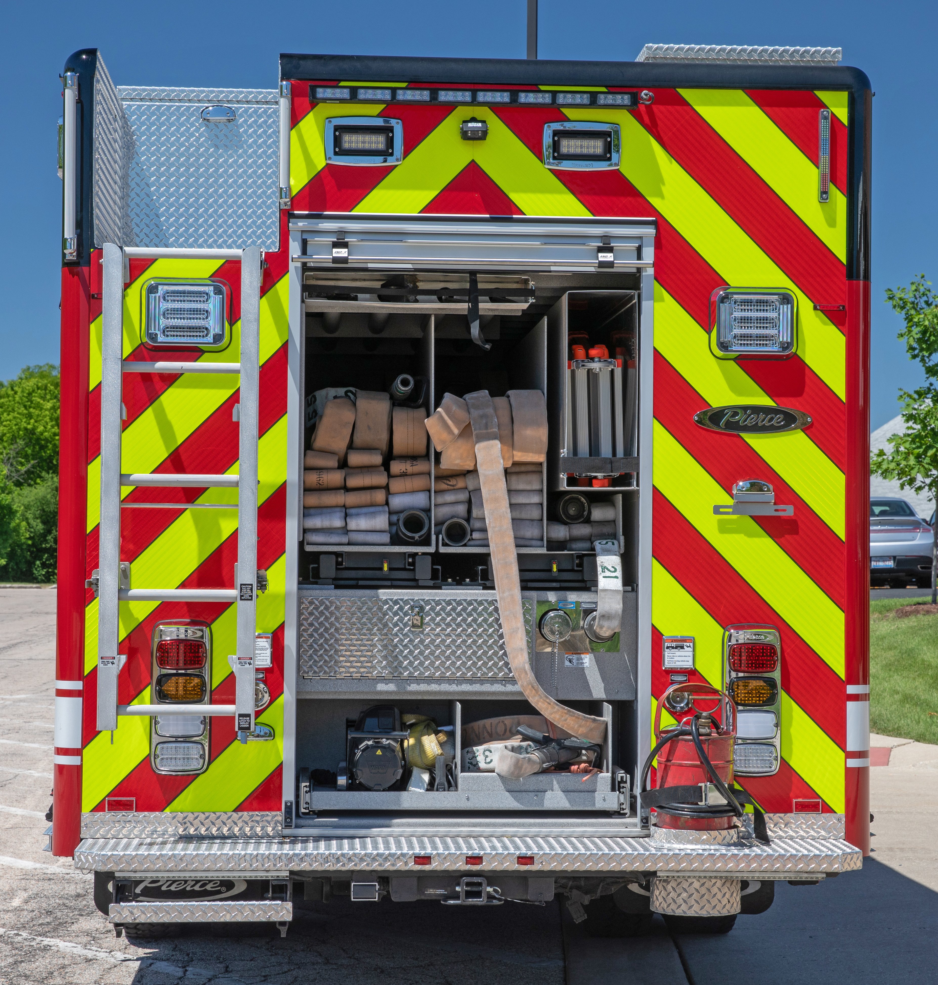 Pierce Non-walk-In Rescue Fire Truck with rear compartment open showing hose bed storage space. 