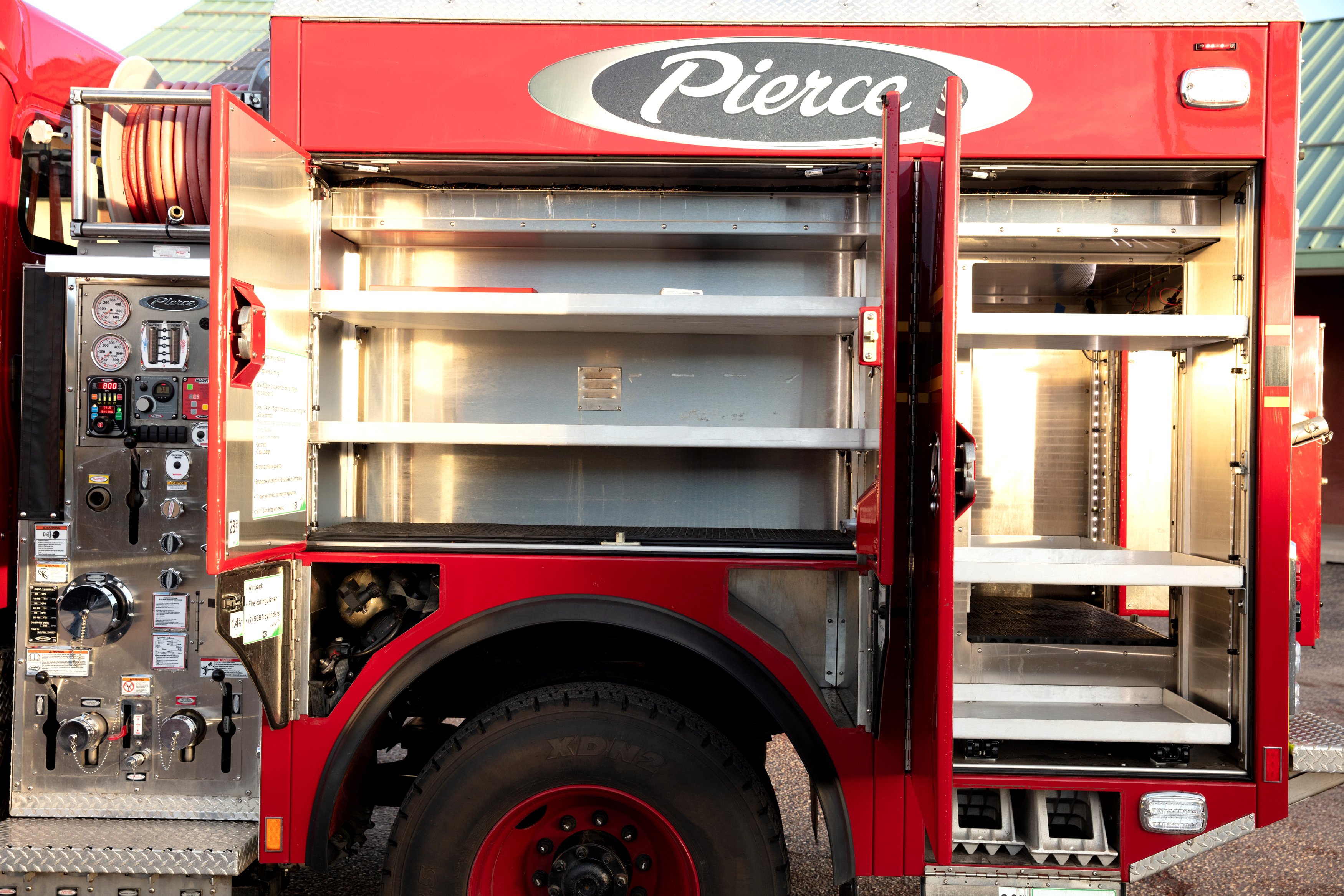 Pierce BX™ Wildland Fire Truck Officer’s side compartments open showing storage space. 